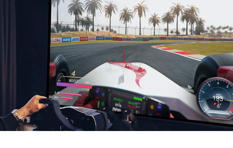 Ένα κοντινό πλάνο ενός παίκτη που κρατάει ένα αγωνιστικό τιμόνι ενώ παίζει σε ένα παιχνίδι αγώνα αυτοκινήτων.