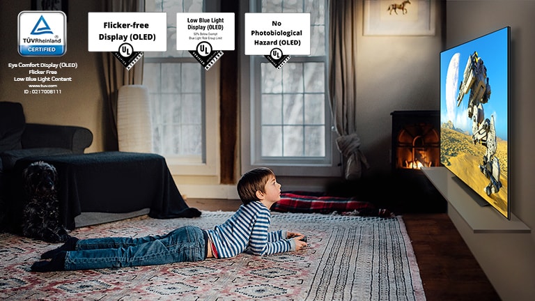 Ένα παιδί ξαπλωμένο στο πάτωμα με ένα χειριστήριο και παίζει ένα παιχνίδι στην τηλεόραση