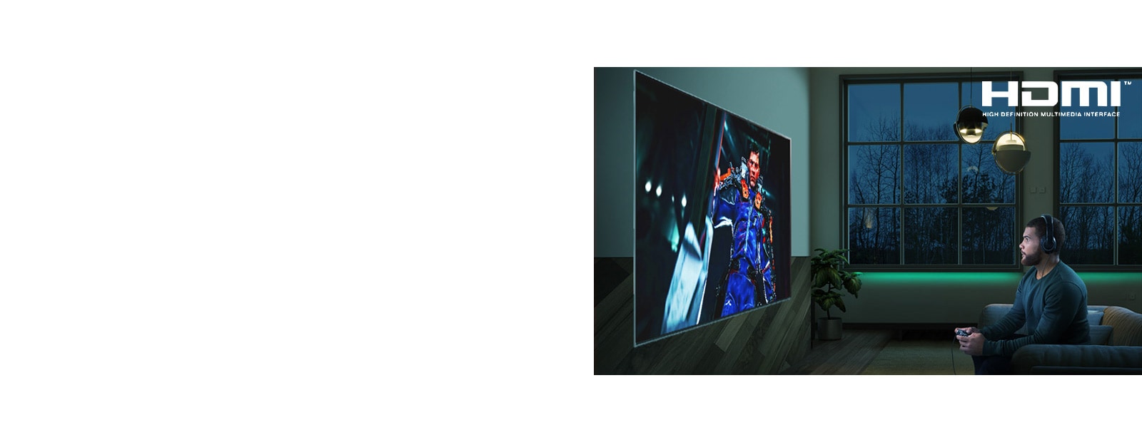 Ένα άντρας κάθεται στον καναπέ κρατώντας ένα joystick και παίζει ένα παιχνίδι στην τηλεόραση.