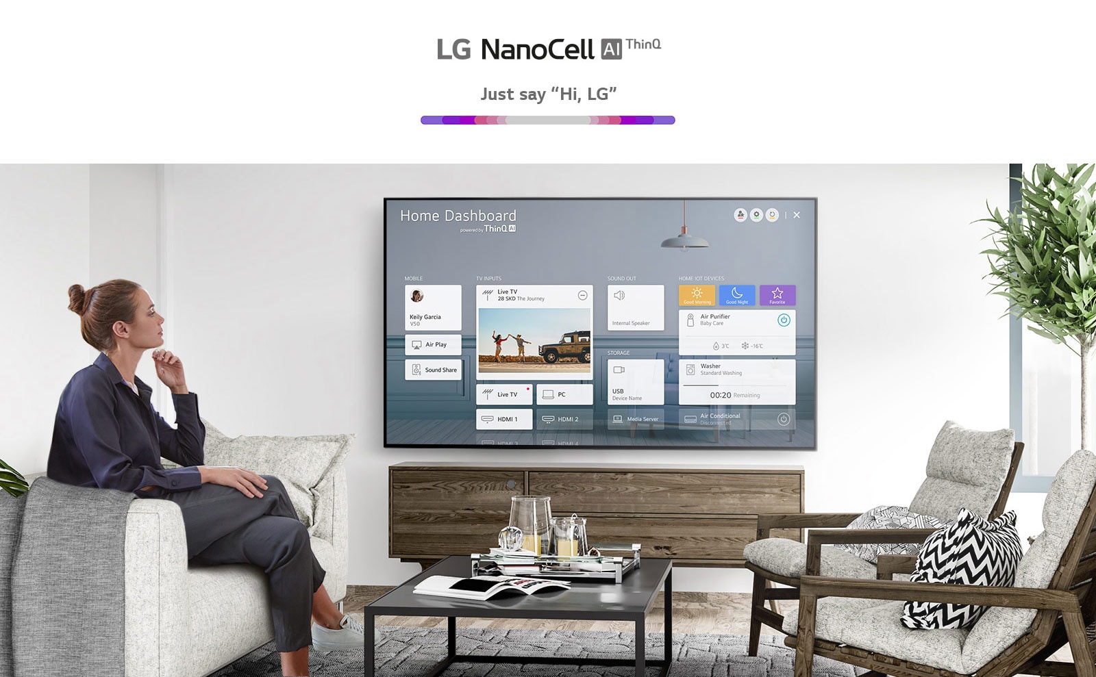 Μια γυναίκα κάθεται σε καναπέ στο σαλόνι με το Home Dashboard στην οθόνη της τηλεόρασης.