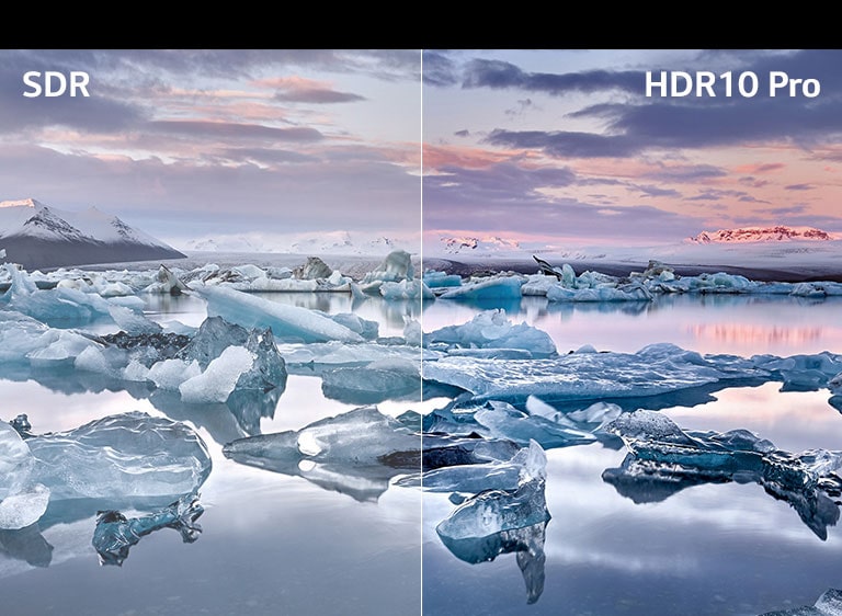 Εικόνα ενός άνδρα που χρησιμοποιεί δύο οθόνες για να επεξεργαστεί τα χρώματα μιας εικόνας που δείχνει μια ομάδα φίλων που κάθονται γύρω από μια υπαίθρια φωτιά.