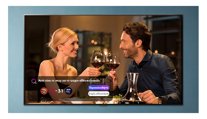 Μια οθόνη τηλεόρασης που απεικονίζει έναν άνδρα και μια γυναίκα που τσουγκρίζουν τα ποτήρια τους, ενώ εμφανίζονται αθλητικές ειδοποιήσεις