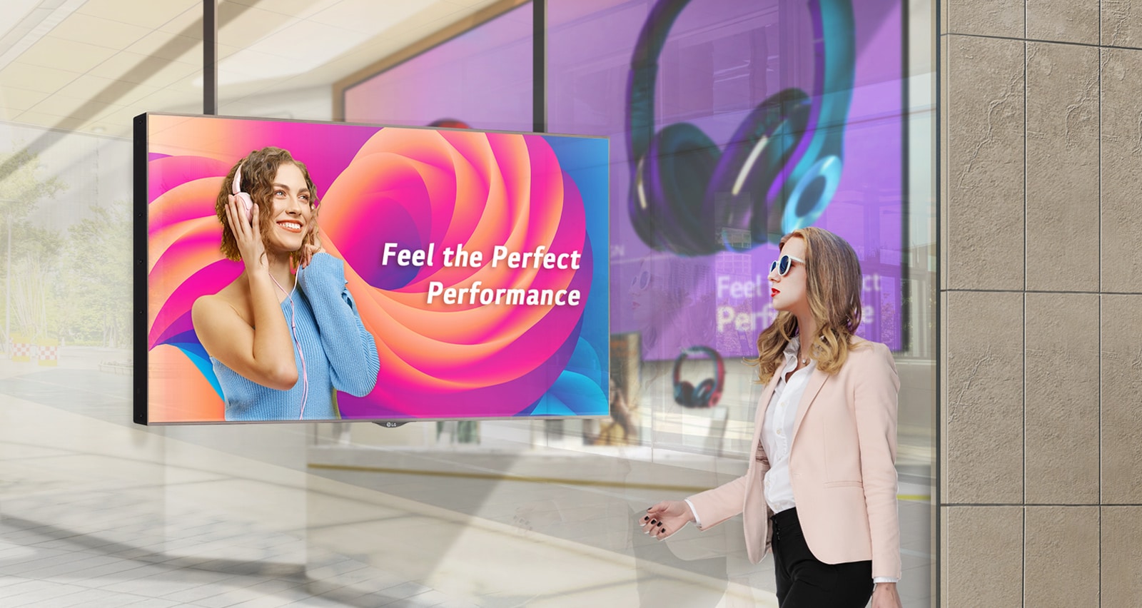 Μια γυναίκα που φορά γυαλιά ηλίου παρακολουθεί διαφημίσεις σε μια οθόνη τοποθετημένη στη βιτρίνα ενός καταστήματος. Οι διαφημίσεις είναι ιδιαίτερα ορατές στην οθόνη ακόμα και στο φως του ήλιου.