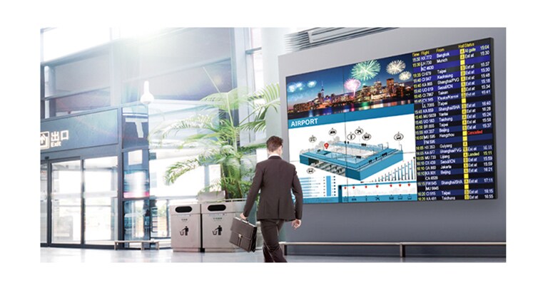 Ένας περαστικός άντρας παρακολουθεί την οθόνη, στην οποία προβάλλονται ζωηρά χρώματα από οποιαδήποτε γωνία.