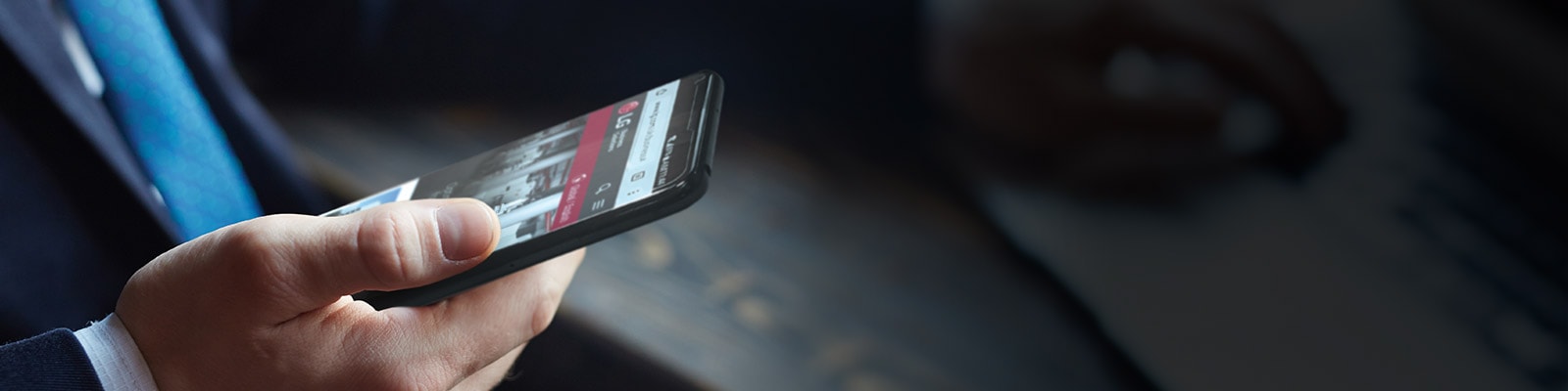 Μια εικόνα ενός άνδρα που κρατά ένα smartphone με την ιστοσελίδα της LG στην οθόνη.