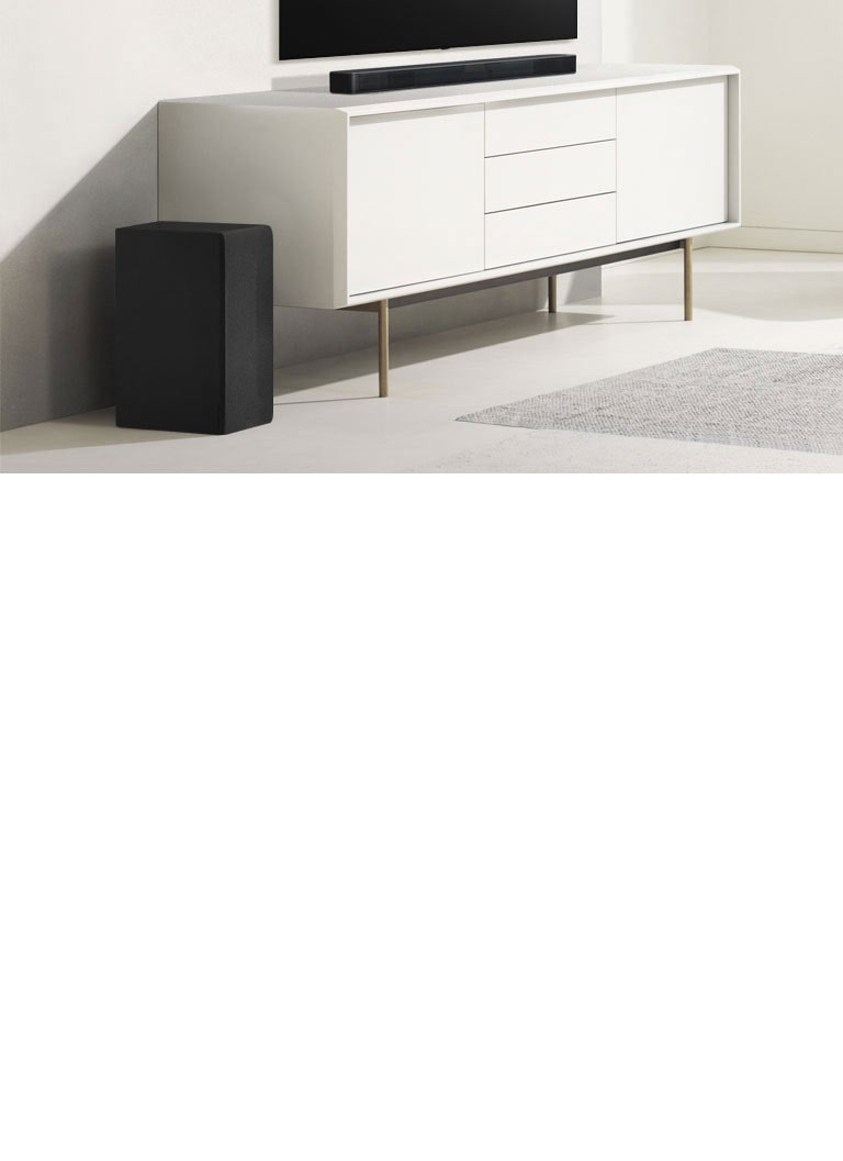 Sound Bar σε ένα λευκό ράφι και αριστερά το Subwoofer. Το Subwoofer προβάλλει περισσότερο.