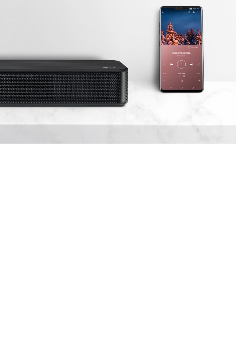 Κοντινό πλάνο της δεξιάς πλευράς του LG Sound Bar, δίπλα στο smartphone. Υπάρχουν δύο συσκευές σε ένα λευκό ράφι.