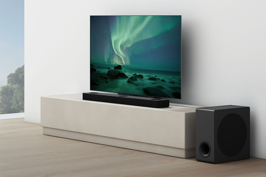 LG Soundbar S80QY, Ένα soundbar τοποθετημένο κάτω από μια τηλεόραση σε ένα σαλόνι με λευκή απόχρωση, με ένα subwoofer τοποθετημένο ακριβώς δίπλα., S80QY, thumbnail 5