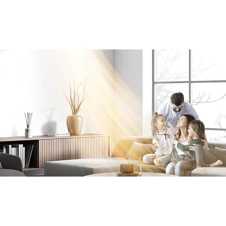 Ο ζεστός αέρας ρέει από την επίτοιχη αντλία θερμότητας καθώς μια οικογένεια σε ένα ζεστό σαλόνι απολαμβάνει τον χρόνο της	