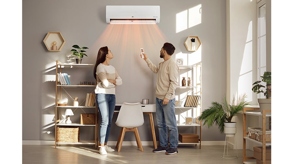 Ζεστός αέρας βγαίνει από συσκευή θέρμανσης και φυσάει έναν άνδρα και μια γυναίκα