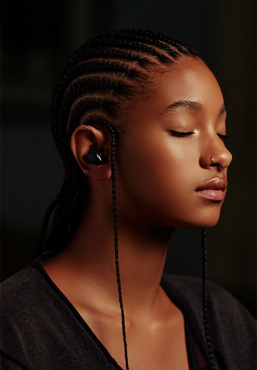 Η Willow Smith ακούει μουσική με τα ασύρματα ακουστικά της, σε προφίλ.