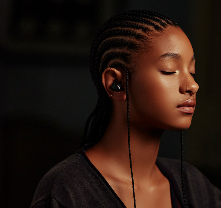 Η Willow Smith ακούει μουσική με τα ασύρματα ακουστικά της, σε προφίλ.