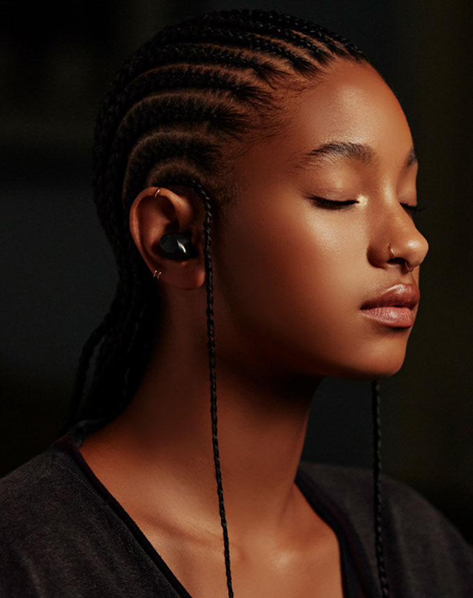 Η Willow Smith ακούει μουσική με τα ασύρματα ακουστικά της, σε προφίλ.