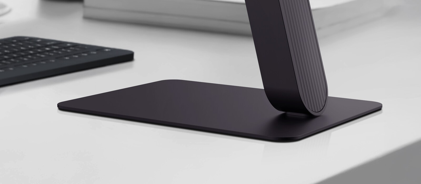 Κοντινή άποψη της βάσης οθόνης LG UltraGear™ σε ένα σύγχρονο γραφείο.
