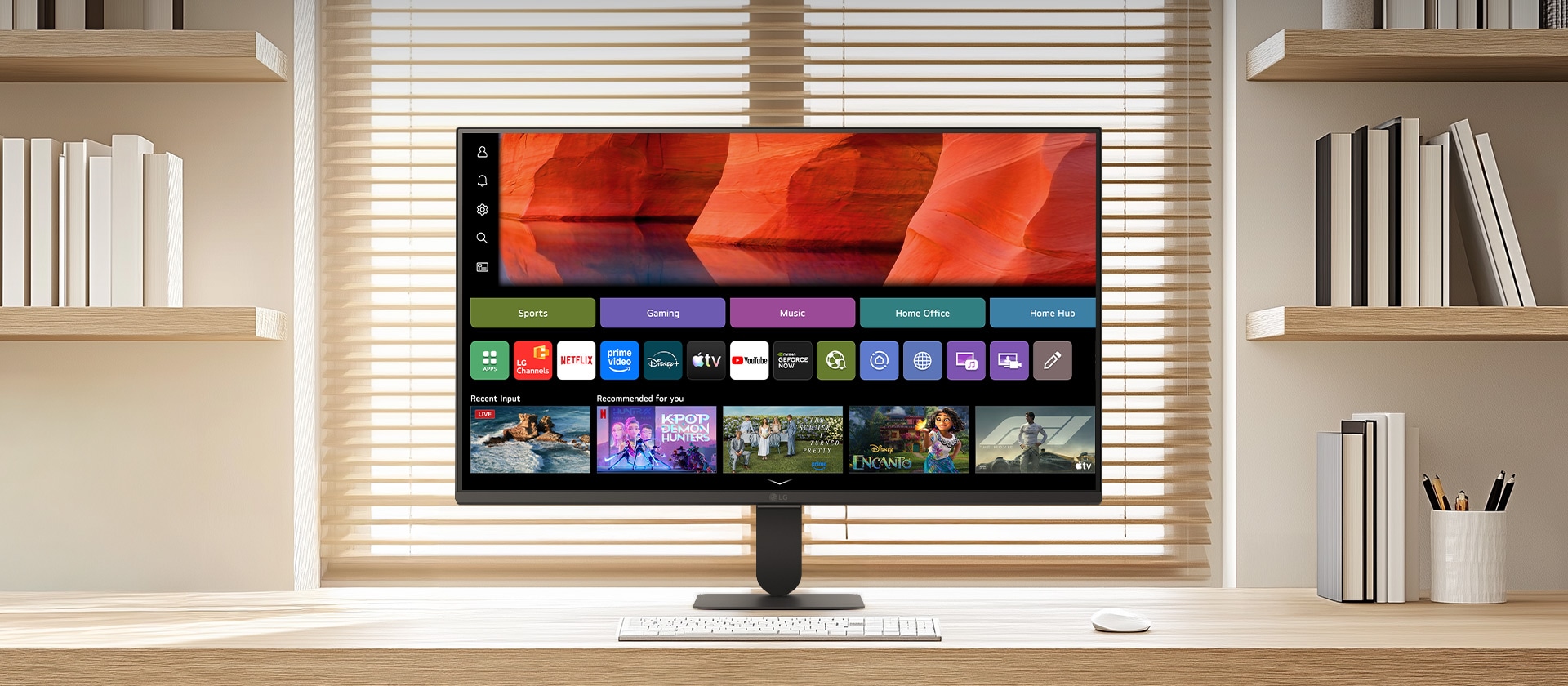 Το LG SMART Monitor σε ένα καθαρό ξύλινο γραφείο σε ένα φωτεινό οικιακό γραφείο, προβάλλοντας την αρχική οθόνη του webOS με εφαρμογές streaming και πλακίδια περιεχομένου, σε συνδυασμό με πληκτρολόγιο και ποντίκι, ράφι και περσίδες παραθύρων στο φόντο, επισημαίνοντας την έξυπνη ψυχαγωγία και την παραγωγική χρήση.