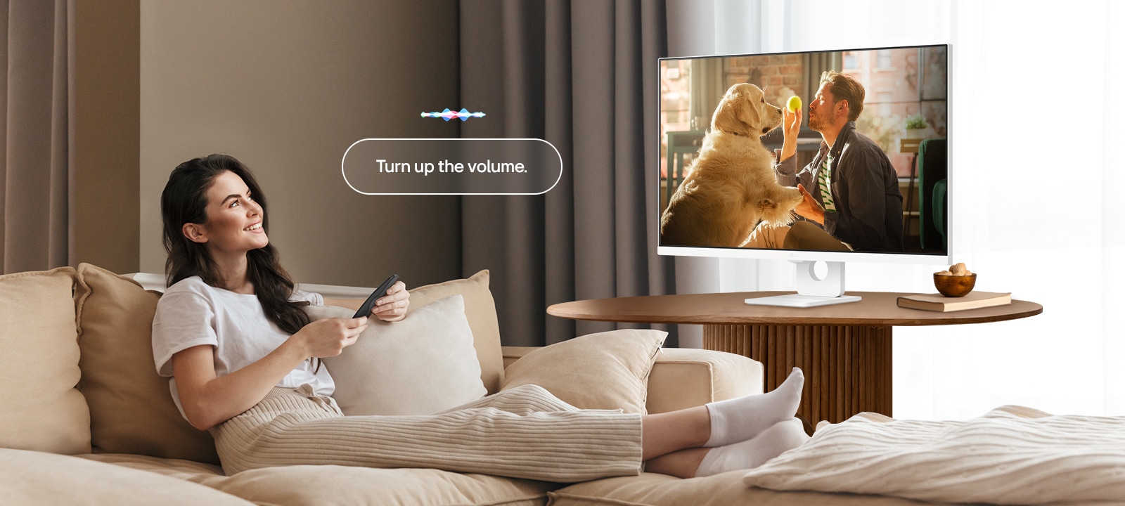 Μια γυναίκα αυξάνει την ένταση του LG Smart Monitor χρησιμοποιώντας ένα Magic Remote.	