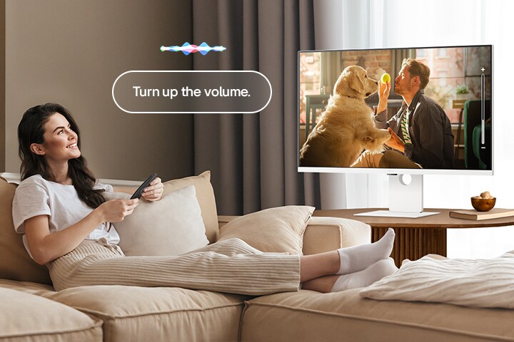 Μια γυναίκα αυξάνει την ένταση του LG Smart Monitor χρησιμοποιώντας ένα Magic Remote.