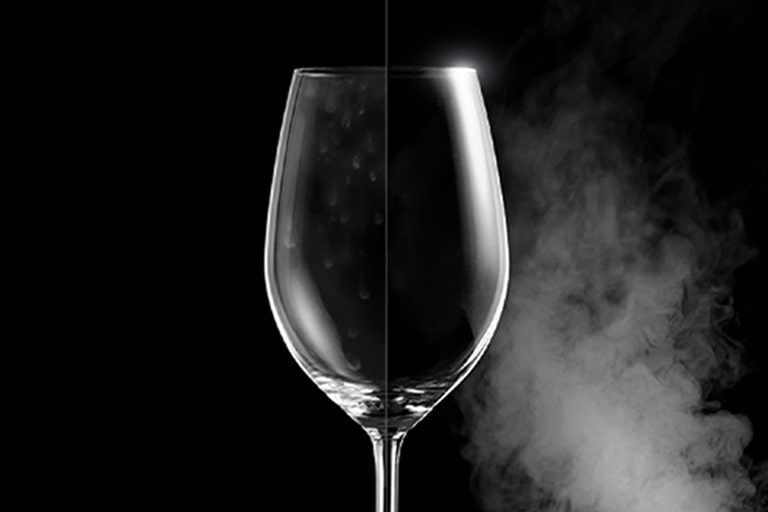 Ποτήρι κρασιού με κηλίδες νερού στη μία πλευρά, και πεντακάθαρο στην άλλη, δείχνει τη διαφορά μετά το πλύσιμο με ατμό.