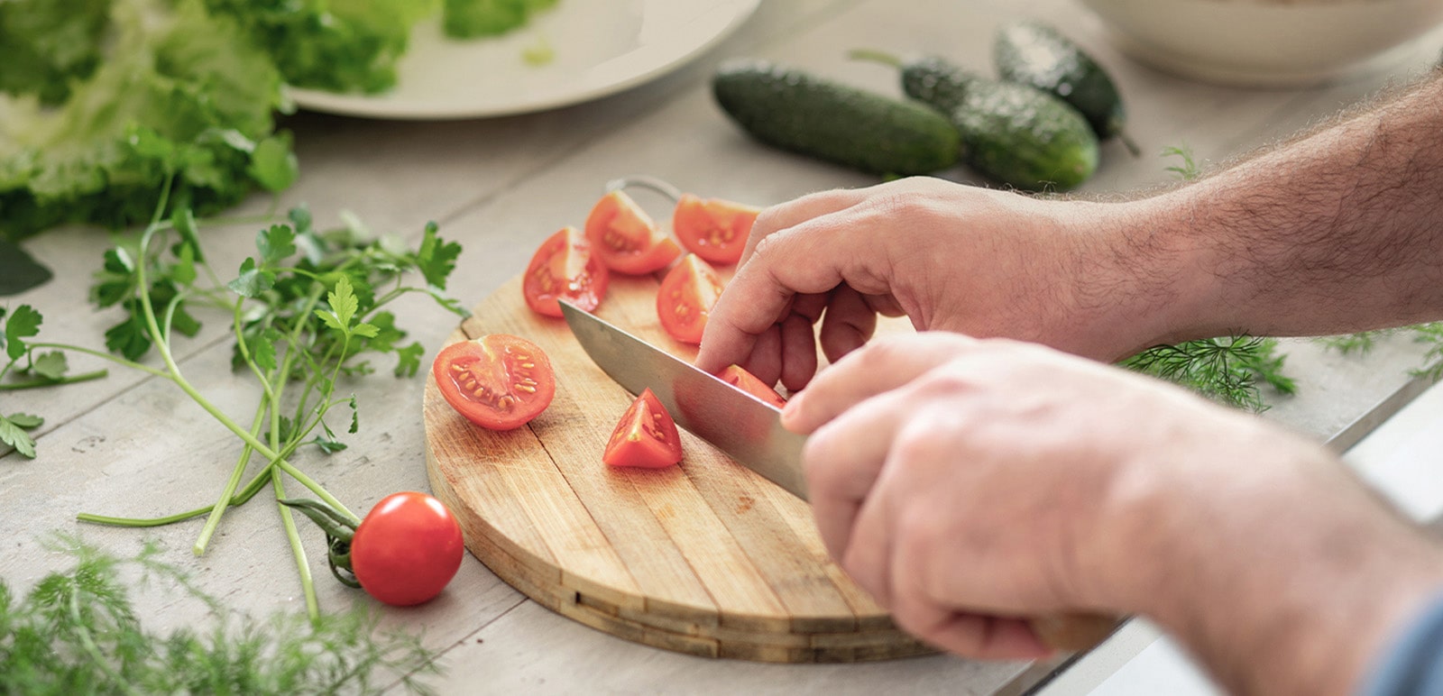 'Μια εικόνα κοπής ντοματών σε μια επιφάνεια κοπής με μαχαίρι.