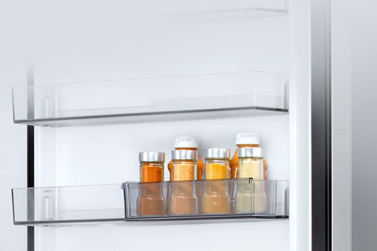 LG ψυγείο bottom freezer εσωτερικό με διάφανο συρόμενομίνι καλάθι για την πόρτα που περιέχει έξι μικρά μπουκάλια σάλτσας.