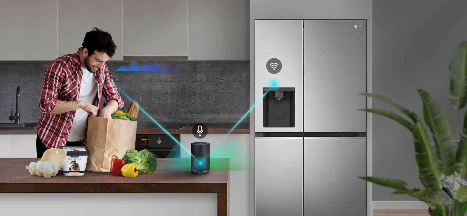 Ένας άντρας βρίσκεται στην κουζίνα, αδειάζει μια τσάντα με λαχανικά και λέει στο ηχείο AI που βρίσκεται στον πάγκο "Ενεργοποίηση Exrpess Freeze". Κοντά του φαίνονται γραμμές έντασης ήχου που ανεβοκατεβαίνουν, υποδεικνύοντας ότι μιλάει στο ηχείο. Εμφανίζεται μια γραμμή που μετακινείται από τον άντρα προς το ηχείο AI, πάνω από την οποία υπάρχει ένα εικονίδιο μικροφώνου. Στη συνέχεια, εμφανίζονται γραμμές έντασης ήχου κοντά στο ηχείο AI και εμφανίζεται μια γραμμή από το ηχείο AI προς το ψυγείο, με ένα εικονίδιο Wi-Fi από πάνω της.