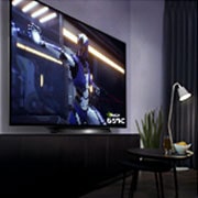 LG BX 65 ίντσες 4K Smart OLED TV, Μία γυναίκα σε ένα καναπέ, κρατάει ένα χειριστήριο ενώ παίζει ένα παιχνίδι στην τηλεόραση, OLED65BX6LB, thumbnail 12