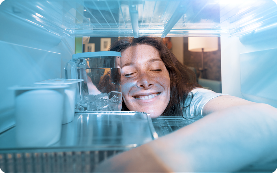 A woman opens a refrigerator to organize the food correctly