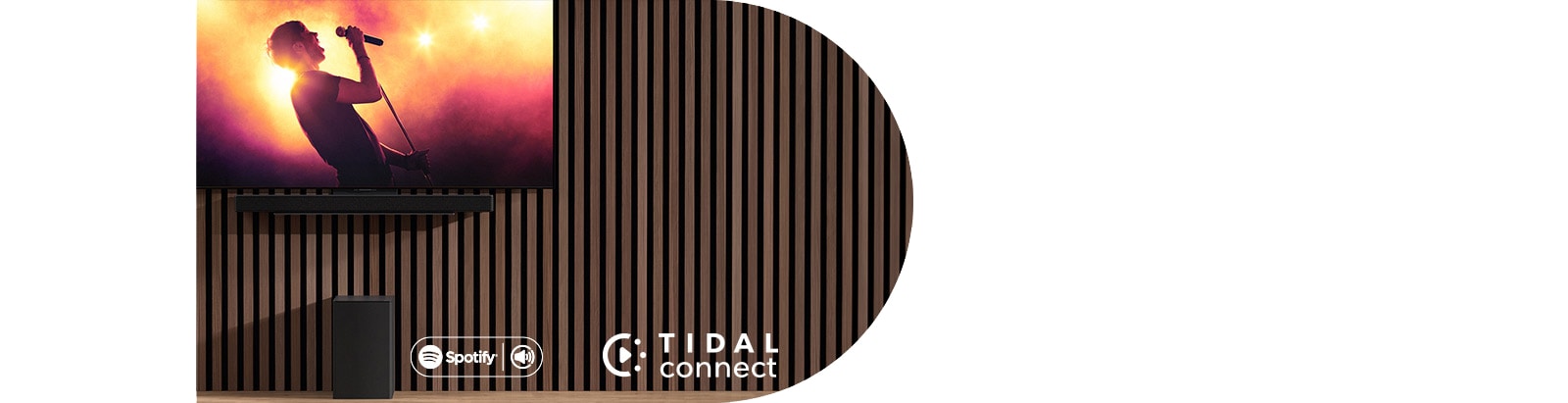 Televizor LG OLED C nalazi se na zidu, a ispod na ekskluzivnom nosaču nalazi se kućno kino LG Soundbar SC9S. Ispod se nalazi subwoofer. Na zaslonu televizora prikazuje se scene koncerta.