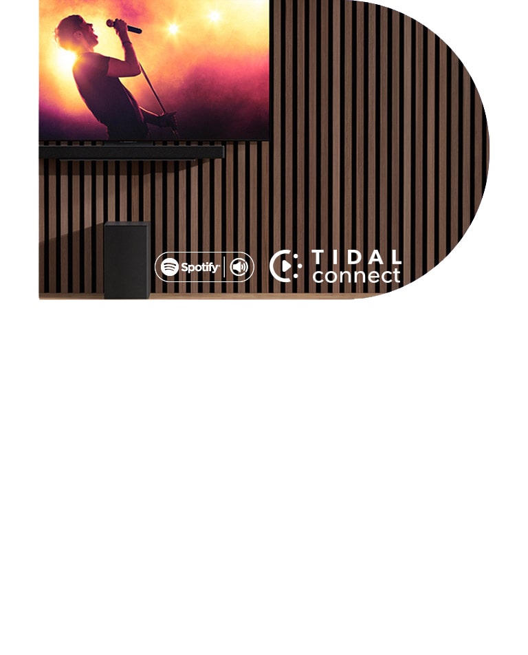 Televizor LG OLED C nalazi se na zidu, a ispod na ekskluzivnom nosaču nalazi se kućno kino LG Soundbar SC9S. Ispod se nalazi subwoofer. Na zaslonu televizora prikazuje se scene koncerta.
