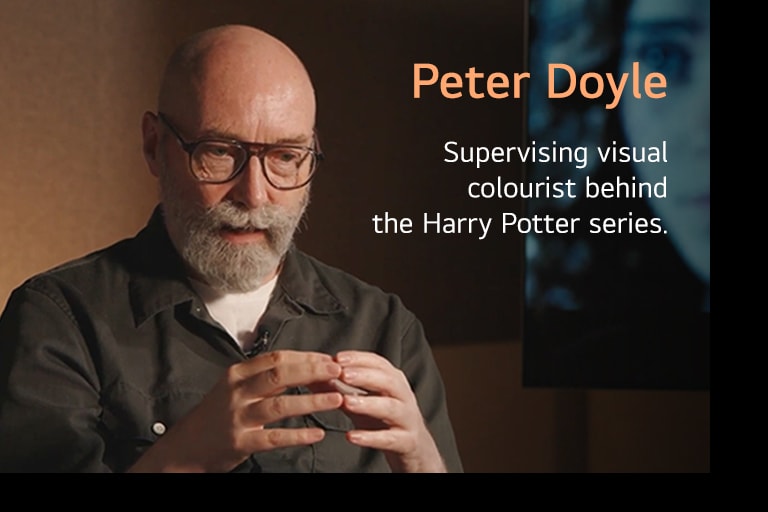 Peter Doyle, supervizor vizualne obrade boje zaslužan za serijal Harry Potter, govori uz gestikulaciju rukama u toplom, nježno osvijetljenom okruženju, stvarajući profesionalnu i promišljenu atmosferu.