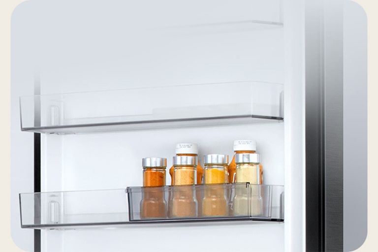 Pogled na unutrašnjost LG hladnjaka s donjim zamrzivačem: šest malih bočica umaka u prozirnom odjeljku s mini vratima s kliznim vratima.