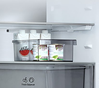 Pogled na unutrašnjost LG hladnjaka s donjim zamrzivačem: sok i posuda za pohranu u pomičnom odjeljku, smještenom iznad ladice FRESHBalancer™.