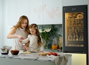 Slika majke i djeteta koji kuhaju dok hladnjak reproducira glazbu.