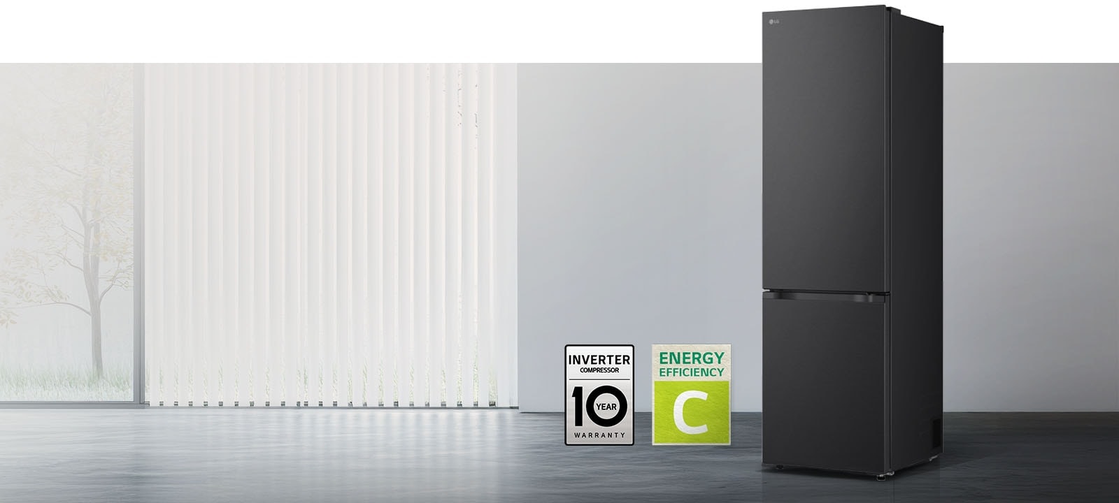 LG mat crni prednji pogled s donjim zamrzivačem u svijetloj prostoriji s vertikalnim žaluzinama, 10-godišnjim jamstvom na kompresor i ikonama energetske učinkovitosti C ispod.