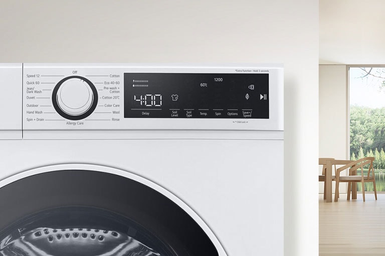 U pozadini je detalj sobe, a u prvom planu pogled izbliza na zaslon perilice rublja.