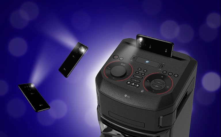 Prikaz izbliza gornje strane sustava LG XBOOM. Oko njega su dva pametna telefona s treperećim svjetlima.