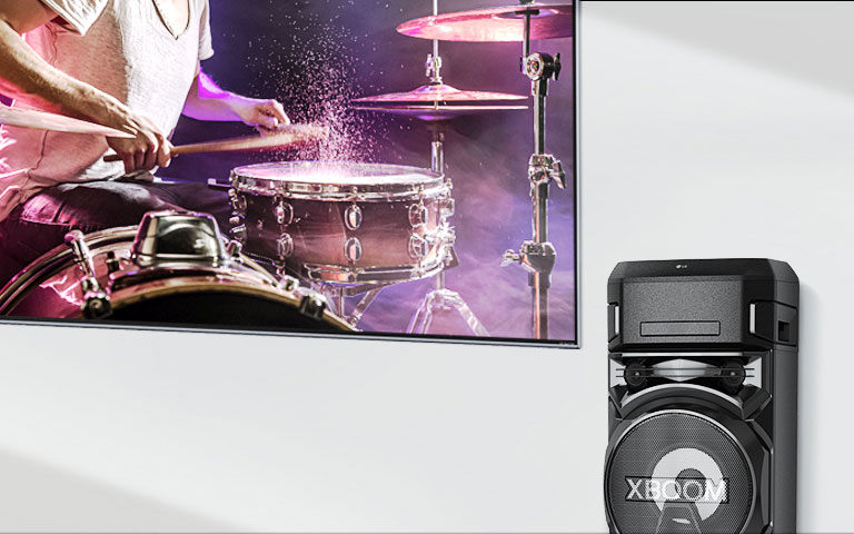 Televizor je na zidu, a njemu zdesna je sustav LG XBOOM.