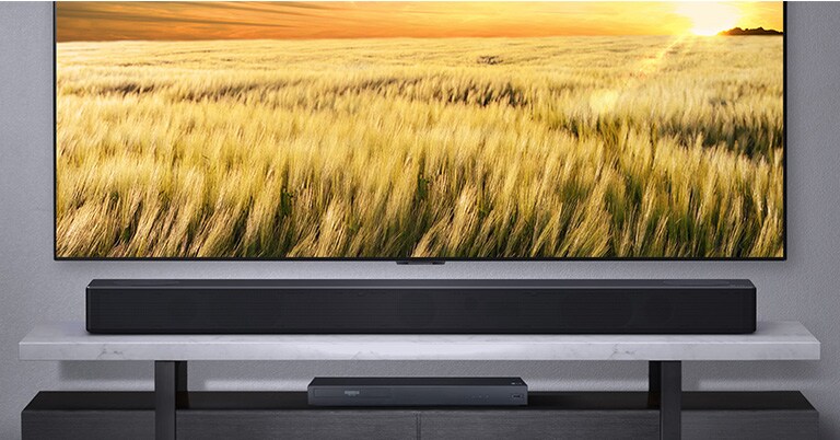 Prednja strana soundbara na podlozi sa spojenim TV-om i uređajem za blue ray reprodukciju