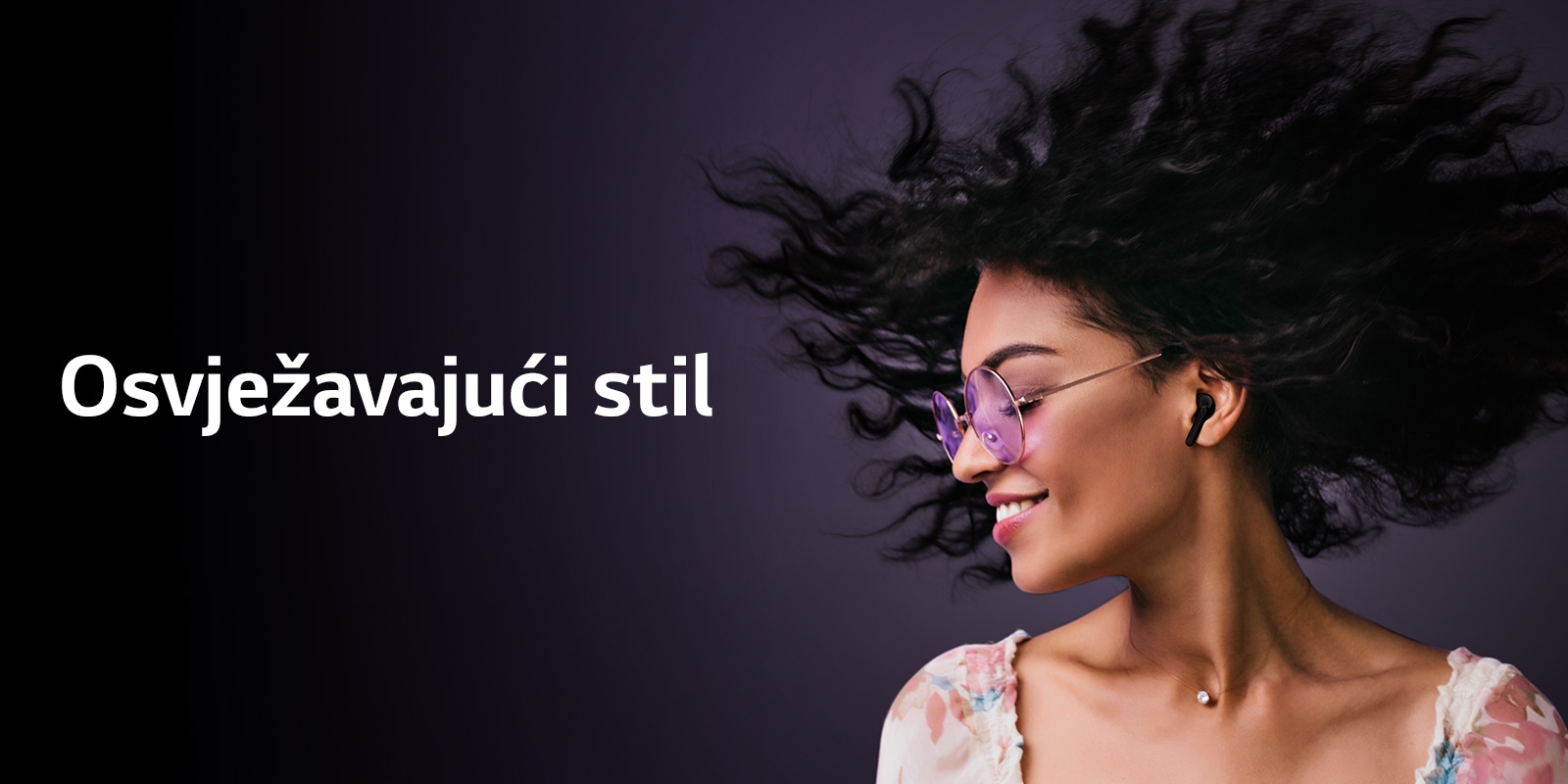 Žena se smiješi dok sluša glazbu putem slušalica TONE Free.