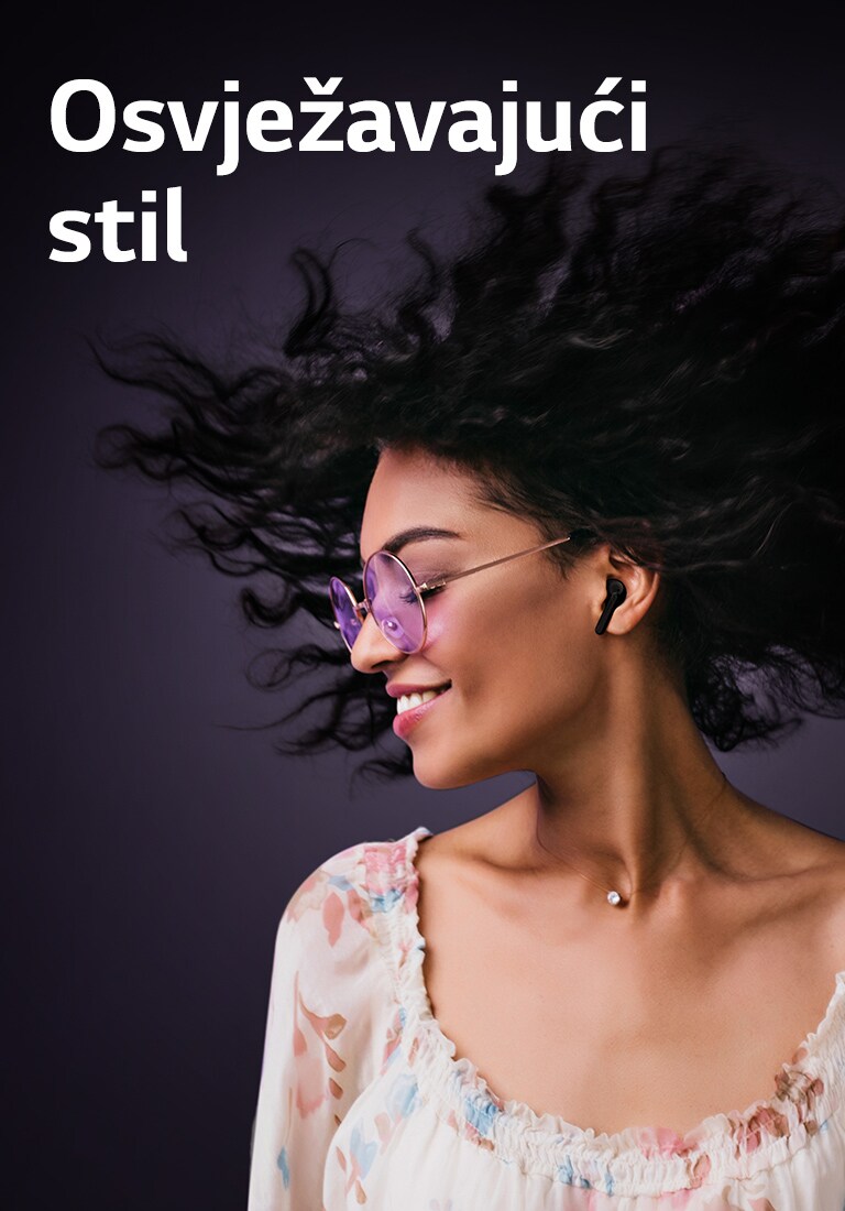 Žena se smiješi dok sluša glazbu putem slušalica TONE Free.