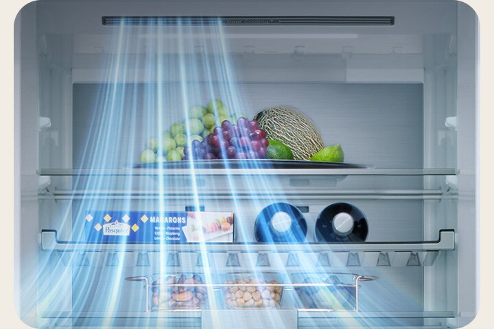 Pogled na unutrašnjost LG donjeg zamrzivača s policama voća, povrća, pića i grickalica s plavim linijama protoka zraka s lijeve strane