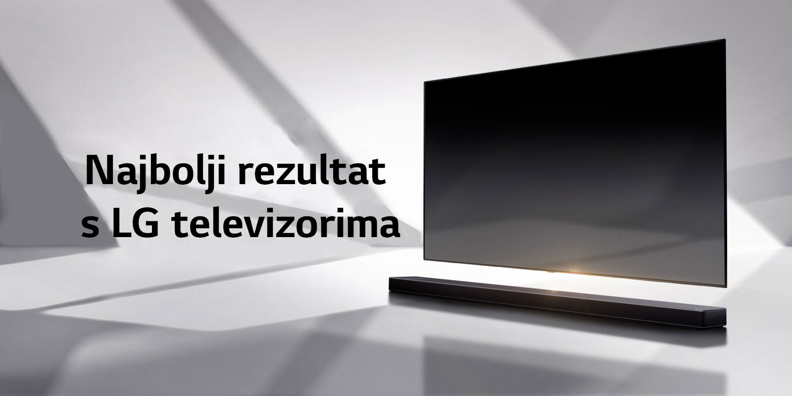 Zvučnik i televizor nalaze se na bijelom podu i u neposrednoj pozadini vidljiva je sjena koja dolazi izvana.