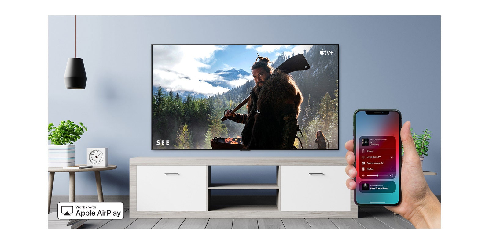 Prikaz izbliza ruke koja upravlja televizorom putem pametnog telefona iPhone i televizor koji prikazuje sadržaj Apple TV+