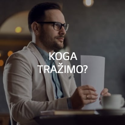 Čovjek sjedi za stolom i drži hrpu papira