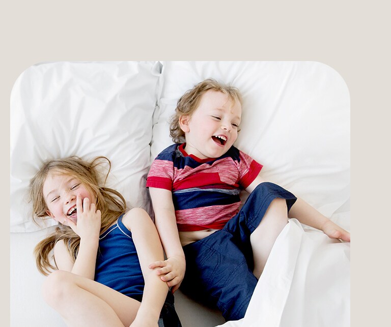 Dvoje djece se igraju oko kreveta