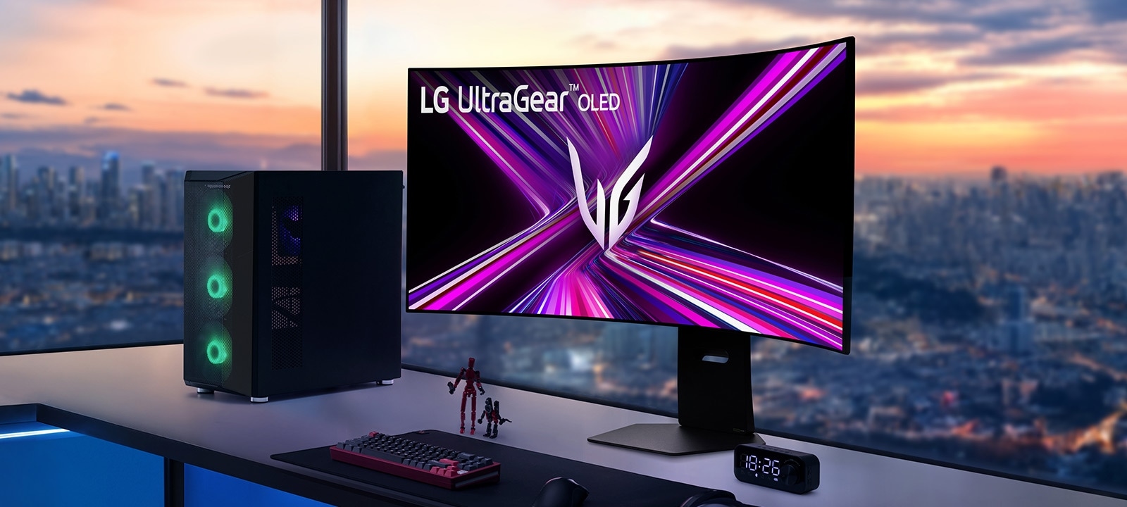 LG UltraGear OLED monitor na gaming stolu s PC setupom, s pogledom na gradski pejzaž pri zalasku sunca.