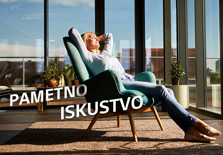 Žena se opušta na stolici u dnevnoj sobi.