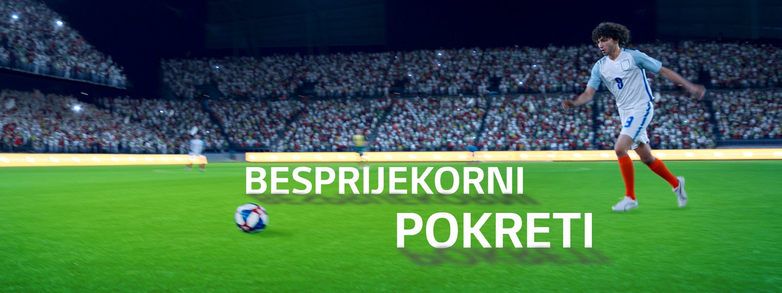 Četiri osobe sjede na kauču i gledaju televizor s velikim zaslonom na kojem se prikazuje nogometni stadion ispunjen gledateljima.