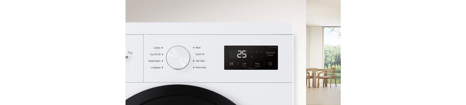 U pozadini je detalj sobe, a u prvom planu pogled izbliza na zaslon perilice rublja.