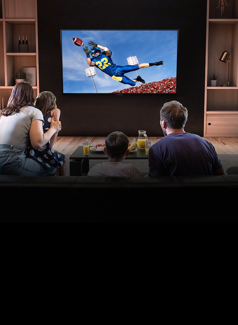 Ljudi koji gledaju utakmicu američkog nogometa na TV-u u dnevnoj sobi